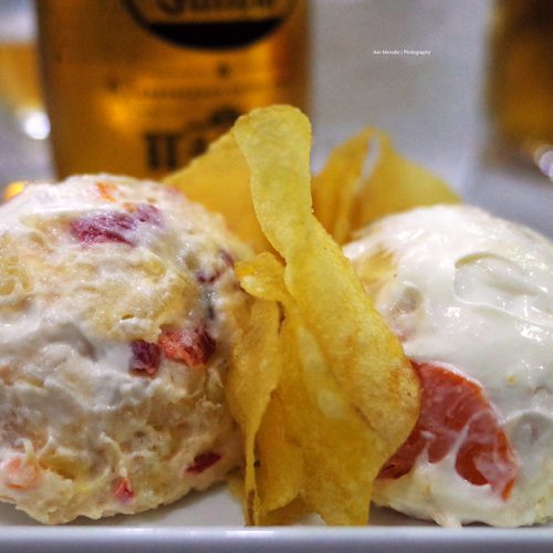 Salade Olivier espagnole servie en deux petits dômes séparés par des chips